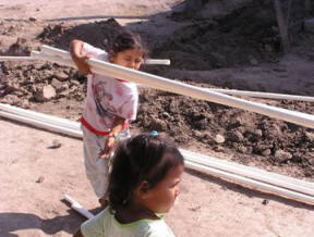 young villager helps carry pipe