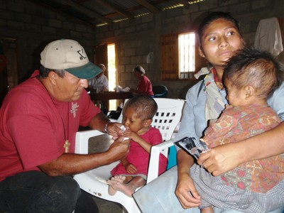 Carlos feeds Plumpy Nut to an extremely malnourished child